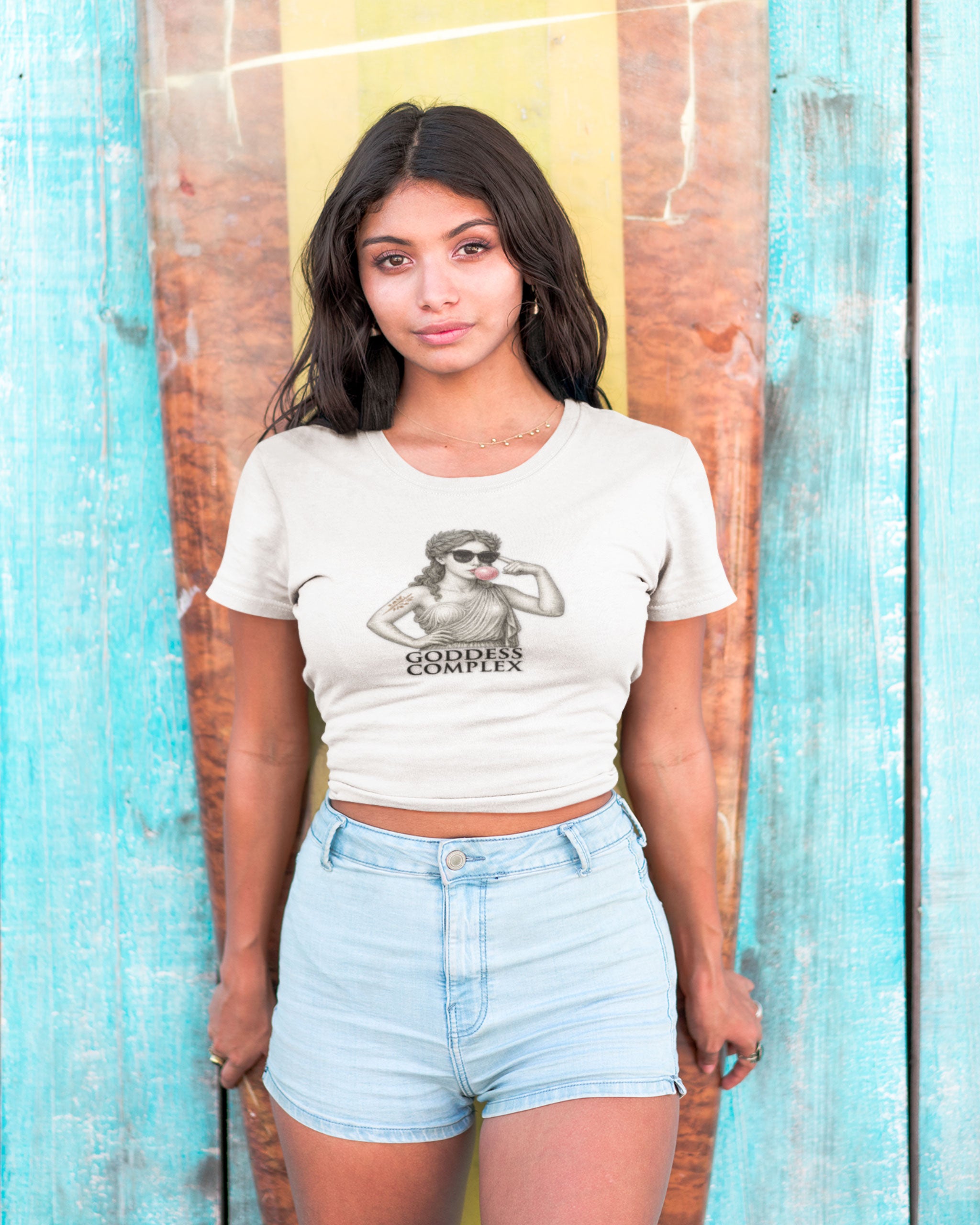 Goddess Complex crop top – Roman statue T-shirt in white, worn by model against rustic turquoise wall