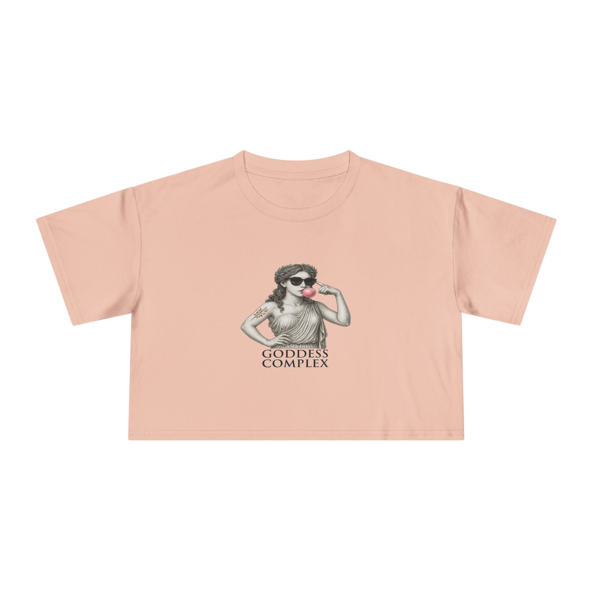 Flatlay of The Goddess Complex crop tee in Pale Pink — soft aesthetic with bold mythic design.
