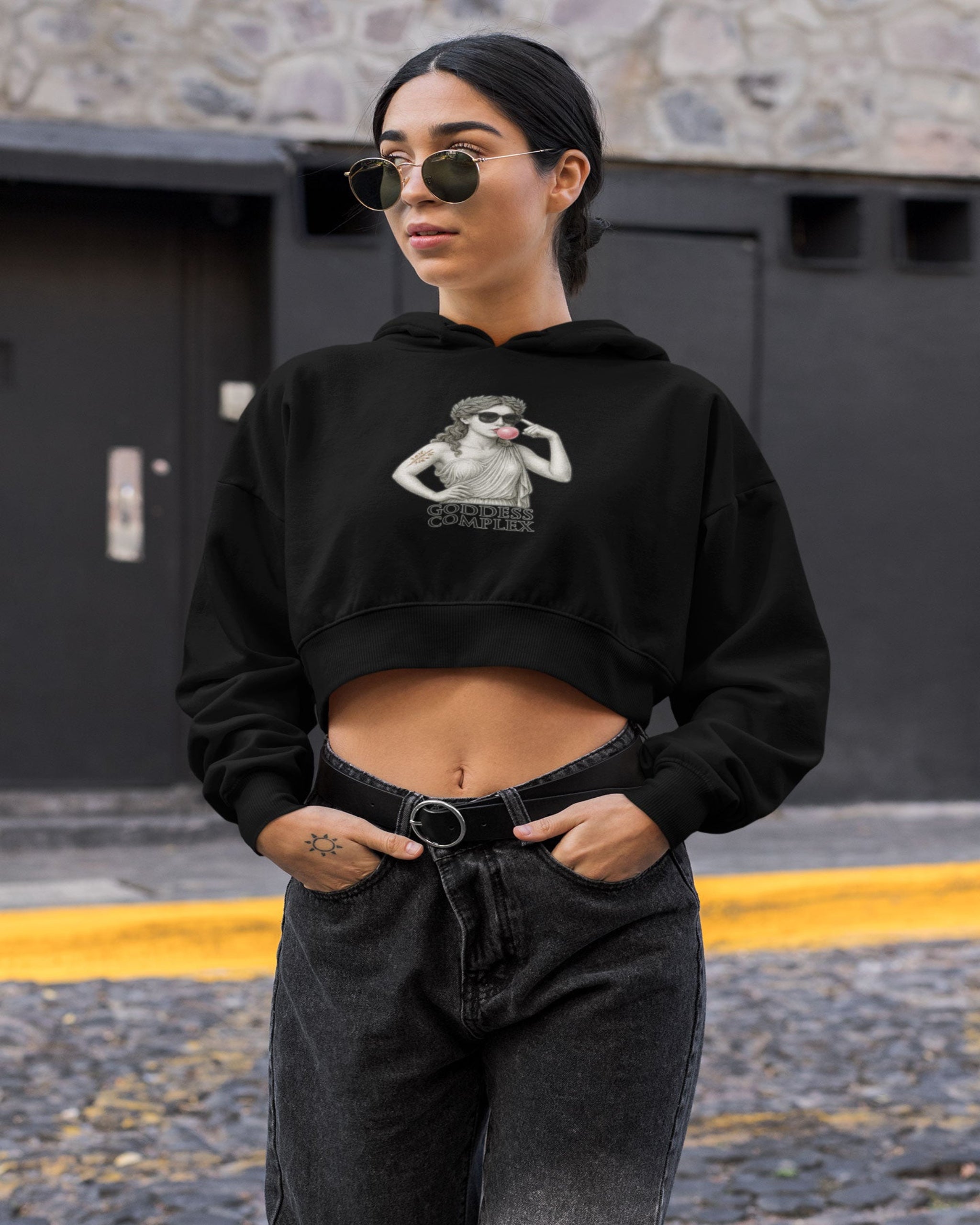 Black crop hoodie with artistic statue design labeled GODDESS COMPLEX. Cropped streetwear silhouette with bold vaporwave influence.