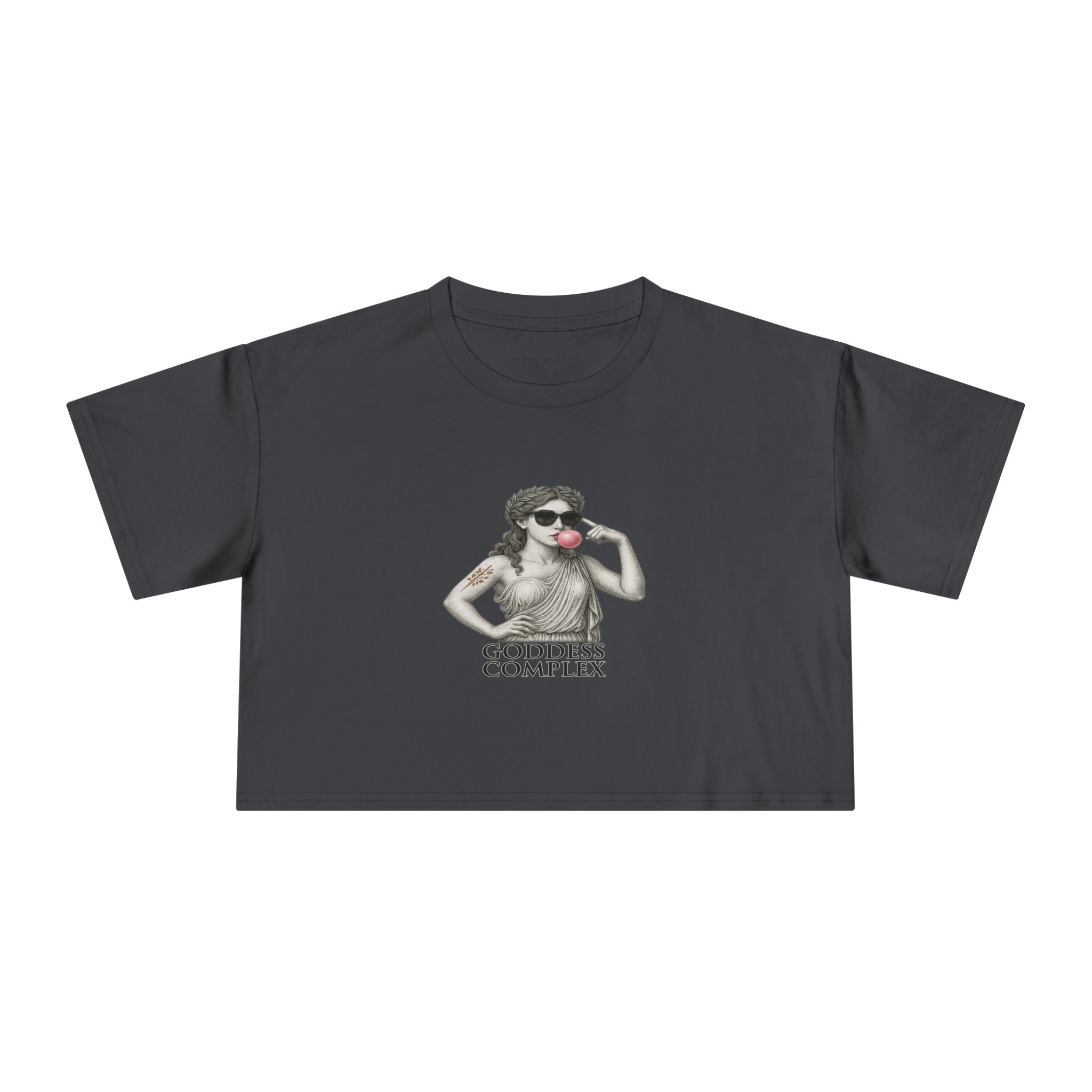 Flatlay of The Goddess Complex crop tee in Coal — dark gray background with contrast graphic.